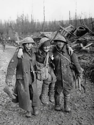 Bringing in an injured man Two soldiers help their wounded comrade, during World War I, photo by National Library of Scotland on Unsplash